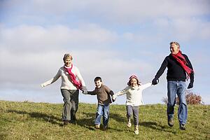 Grandparents And Grandchildren Running In The Park