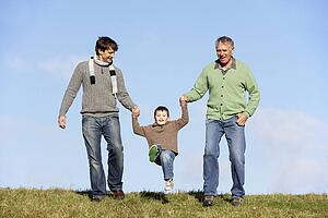 Father And Grandfather Swinging Young Boy