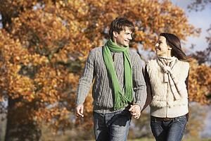 Young Couple Walking In Park Holding Hands
