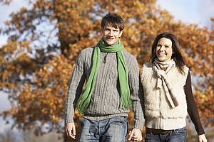 Young Couple Walking In Park Holding Hands