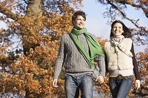 Young Couple Walking In Park Holding Hands