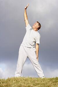 Senior Man Stretching In The Park
