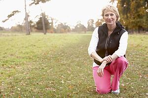 Portrait Of Senior Woman Crouching In The Park