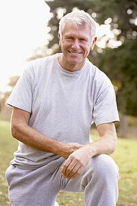Portrait Of Senior Man Crouching In The Park