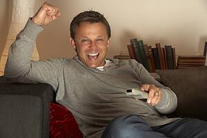 Man Watching Television Excitedly