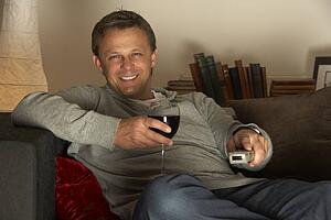 Man With Glass Of Wine Watching Television