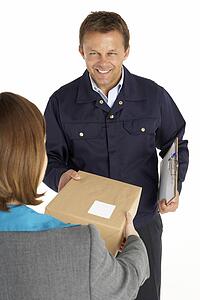 Courier Handing Over A Parcel To An Office Worker