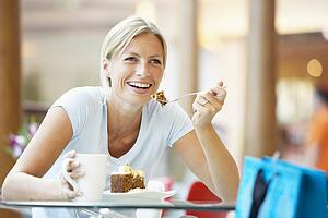 Woman Eating A Piece Of Cake At The Mall