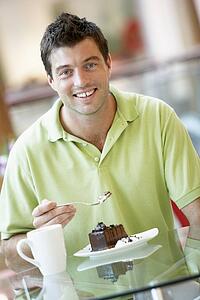 Man Eating A Piece Of Cake At The Mall