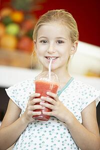 Young Girl Drinking A Berry Smoothie