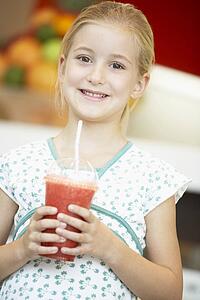 Young Girl Drinking A Berry Smoothie