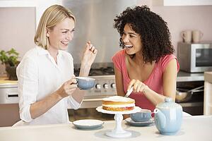 Female Friends Enjoying Tea And Cake At Home