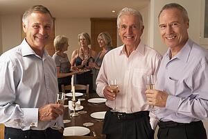 Friends Enjoying A Glass Of Champagne At A Dinner Party