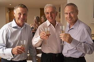 Friends Enjoying A Glass Of Champagne At A Dinner Party