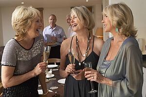 Friends Enjoying A Glass Of Champagne At A Dinner Party