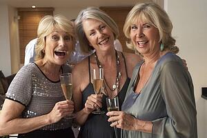Friends Enjoying A Glass Of Champagne At A Dinner Party