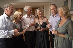 Friends Enjoying A Glass Of Champagne At A Dinner Party