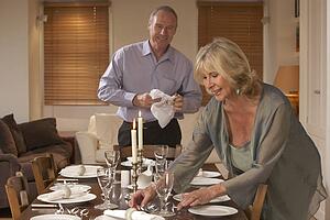 Couple Preparing Table For A Dinner Party