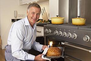 Man Taking Food Out Of The Oven