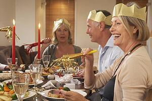 Friends Wearing Party Hats At A Dinner Party