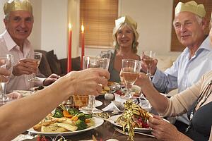 Friends Wearing Party Hats At A Dinner Party