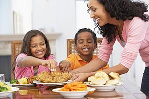 Mother Serving A Meal To Her Children At Home