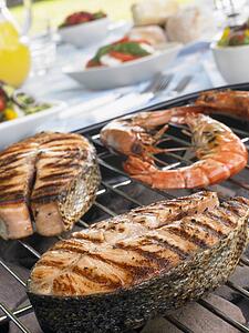 Salmon And Prawns Cooking On A Grill