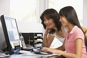 Woman Watching Her Daughter Use A Computer