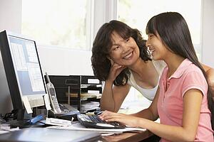 Woman Watching Her Daughter Use A Computer