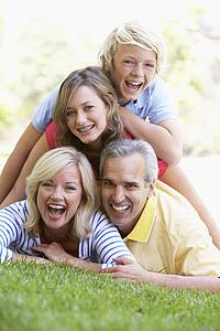 Family Lying On Top Of Each Other In A Park