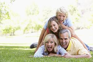 Family Lying On Top Of Each Other In A Park