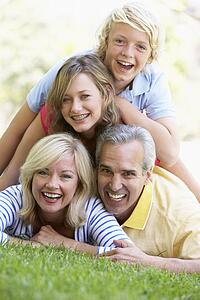 Family Lying On Top Of Each Other In A Park