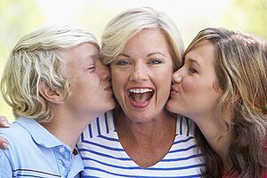 Woman Being Kissed By Her Teenage Children