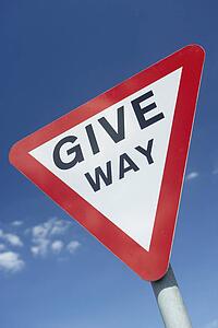 Give Way Sign Against A Blue Sky