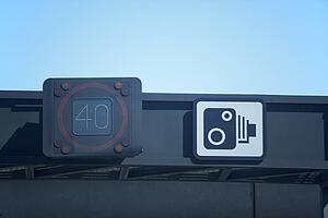 Speed Detector Next To A Speed Camera Warning Sign