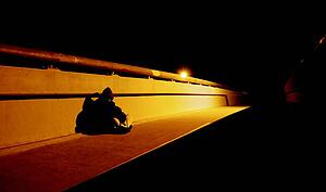 Homeless person on bridge at night
