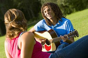 Boy playing the guitar for a girl