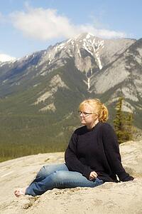 Young woman sitting in the mountains, Jasper, Canada