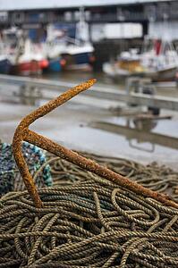 East Riding, Yorkshire, England; Rusty anchor and piles of rope on the seafront