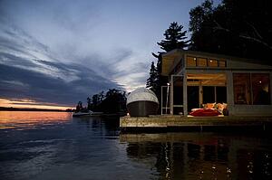 Lake of the Woods, Ontario, Canada; House set over the lake facing sunset