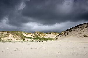 Islay, Scotland; Storm clouds over a beach