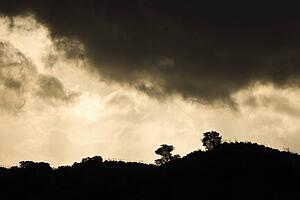Ridge of a hill set against stormy sky 