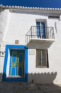 Macharaviaya, Malaga Province, Spain; house with blue and yellow door 