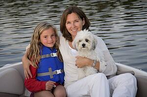 Mother and daughter with dog in boat, Lake of the Woods, Ontario, Canada