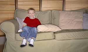 Boy sitting on couch, smiling