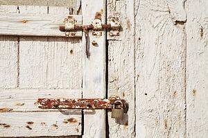 Rusted lock and bolt on a weathered wooden door