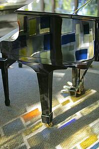 Piano with stained glass reflection
