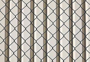 Barbed wire fence and wall behind