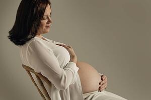 A mother looks at her pregnant belly