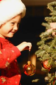 Girl Hanging Ornament on Christmas Tree